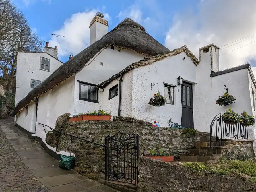 Limewashed rendered cob cottage with small deep-set windows of the type found in villages near Exeter