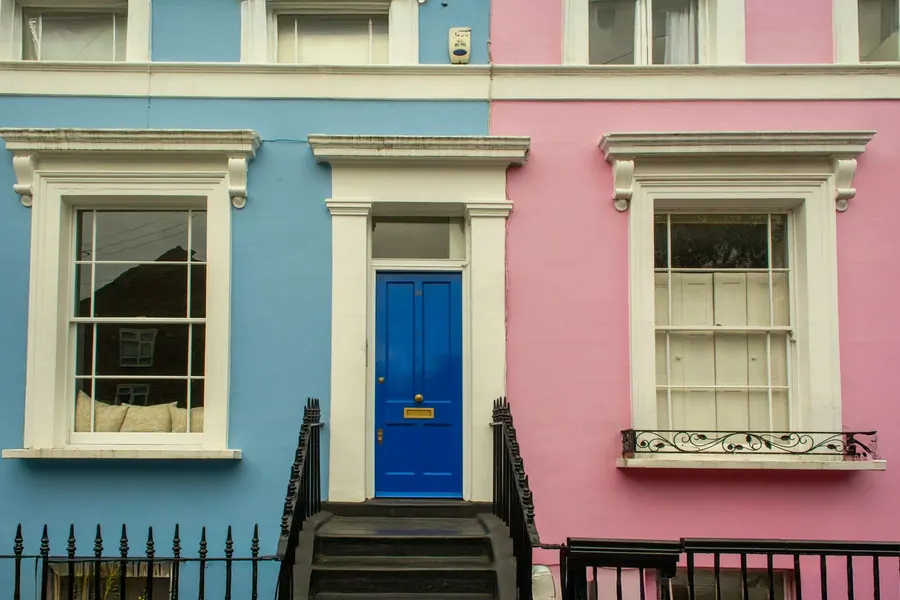 Painted rendered Georgian town houses with white sash windows and glazing bars, the kind of frontage found on Crediton's rebuilt High Street