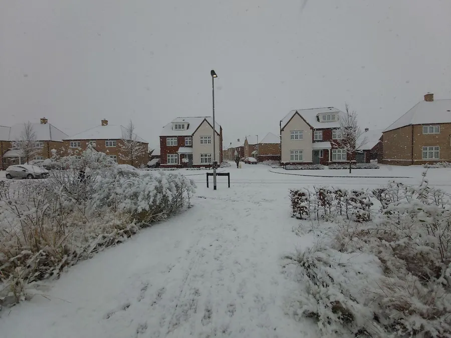 Modern brick and render estate houses with white uPVC windows after a snowfall, typical of the newer housing on the edges of Crediton and Tiverton