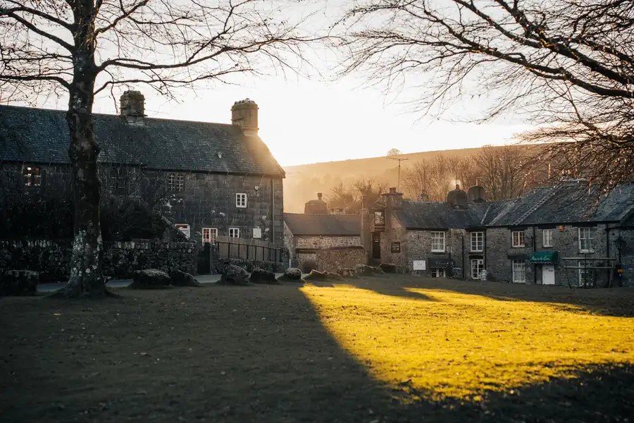 Granite cottages and slate roofs around a village green at sunrise on Dartmoor, the kind of building stock found around Chagford