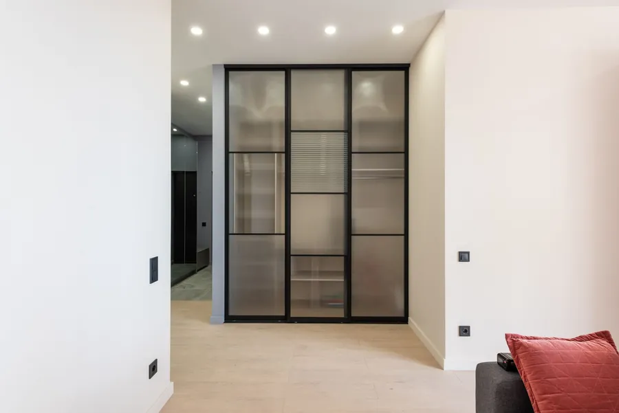 Black framed internal glazed doors with reeded glass in a bright hallway, an internal steel-look screen of the kind fitted in Exeter homes
