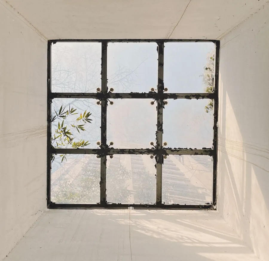 Slim black gridded window set deep in a white reveal, the look slim aluminium steel-look systems are designed to copy