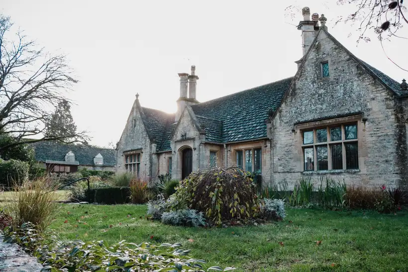 Stone almshouse with mullioned windows and leaded lights, the kind of listed building where steel-look replacements need consent
