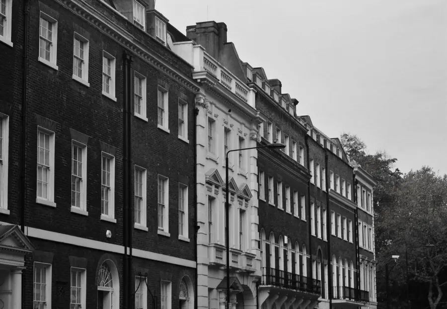 Row of tall Georgian brick town houses with sash windows, the kind of period frontage found in Tiverton's conservation area