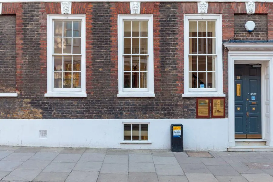 Brick period house front with tall painted timber sash windows divided by glazing bars, typical of listed merchants' houses in Topsham
