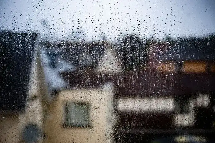 Rain falling on a house in wet weather - how Devon's rainfall affects uPVC vs timber window choice in Exeter
