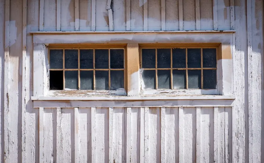 Rotting timber window frame with peeling paint - timber window maintenance and rot in Devon's wet climate