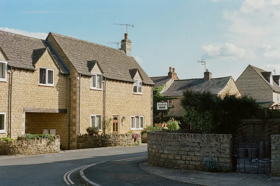 Stone-faced houses with white uPVC windows on a quiet residential street