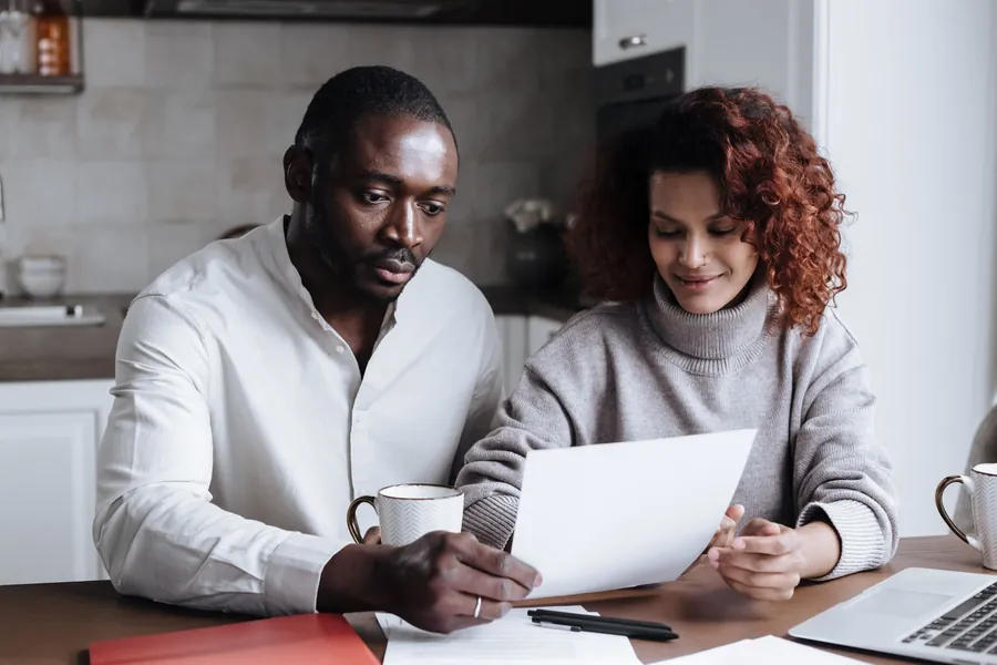 Couple comparing window quotes at a kitchen table - how to read the glass specification and compare two prices