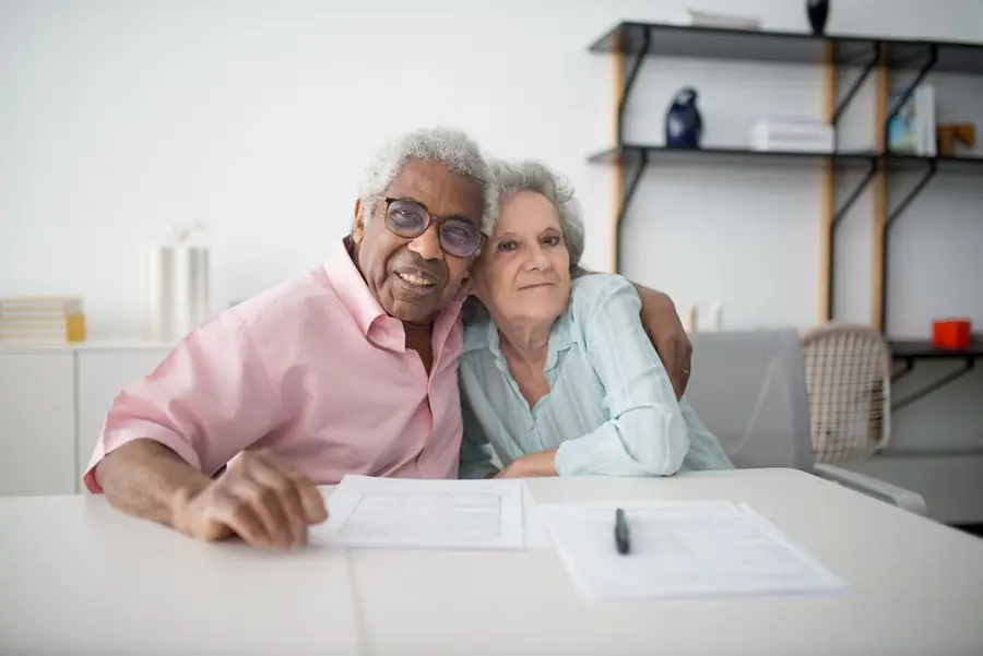 A couple checking paperwork and eligibility documents at home - both income and EPC criteria must be met