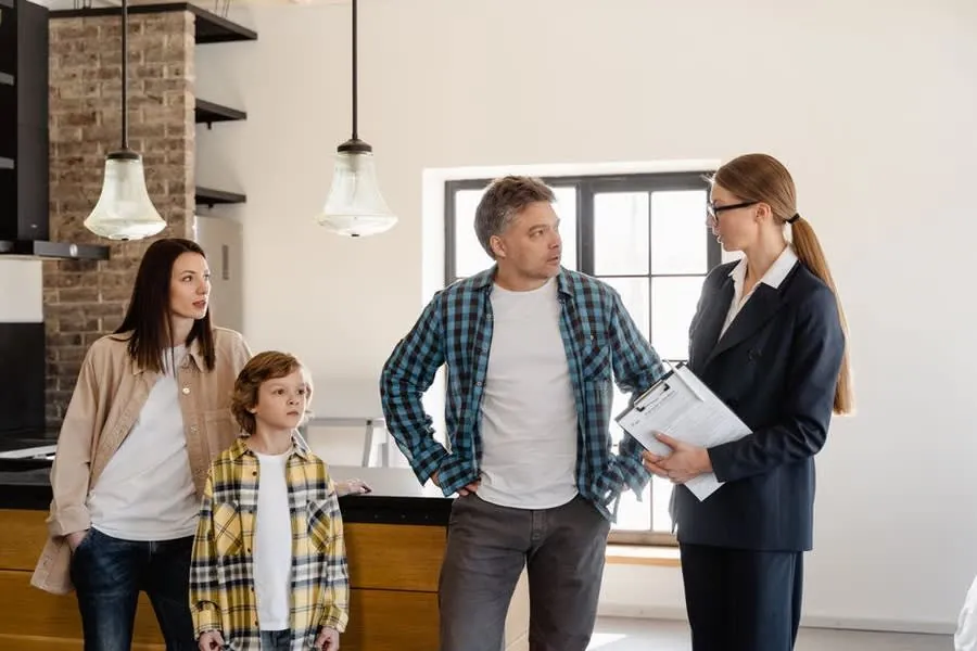 Homeowners discussing a replacement window quote with an installer in Exeter