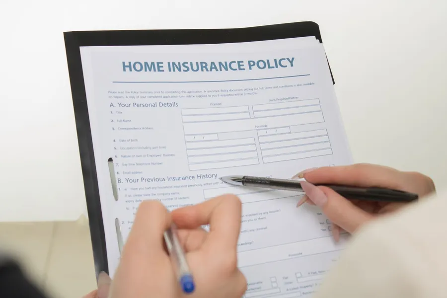 Home insurance policy document being completed, illustrating insurance-backed guarantees for windows in Exeter