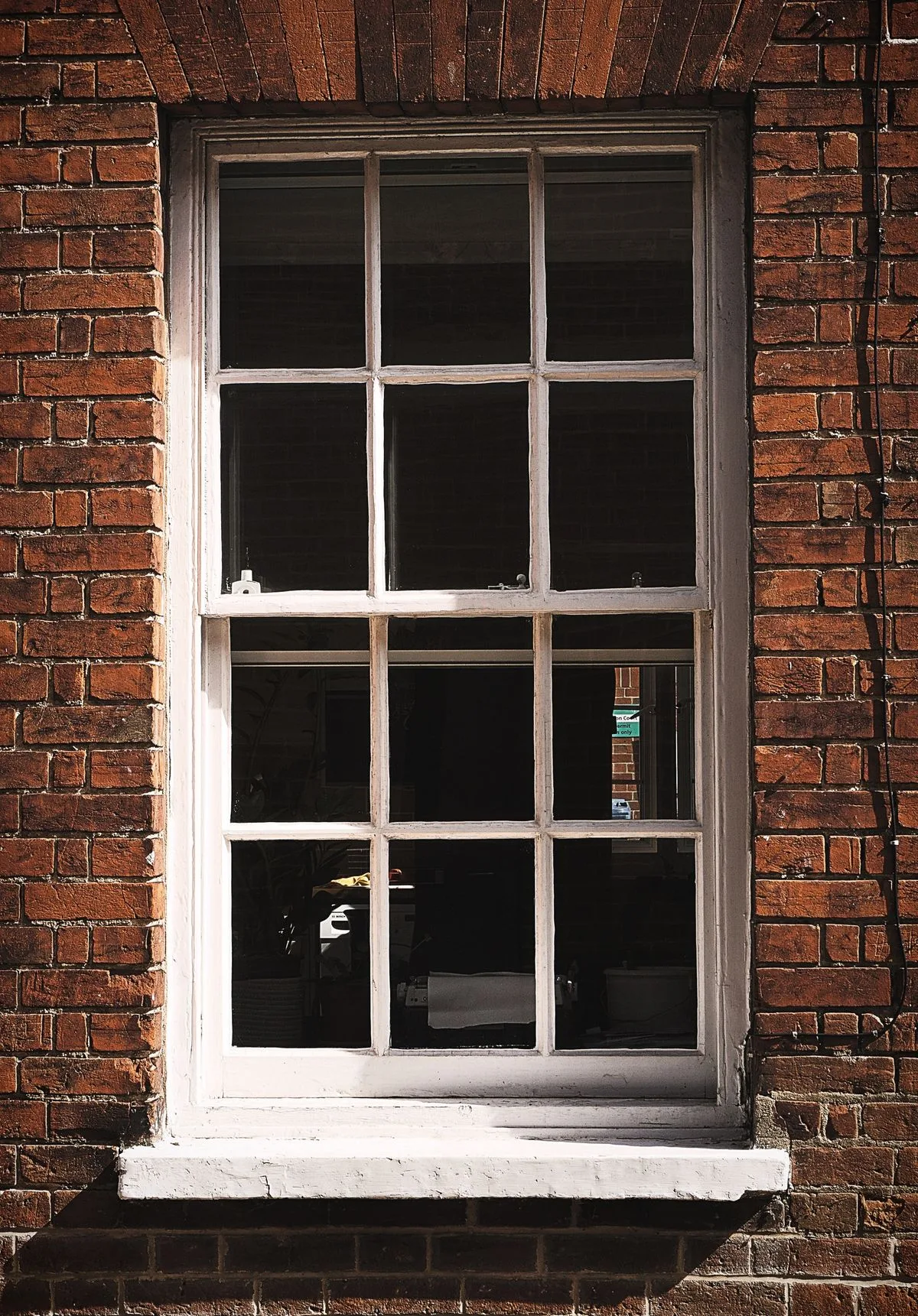 White sash window against Exeter brick wall