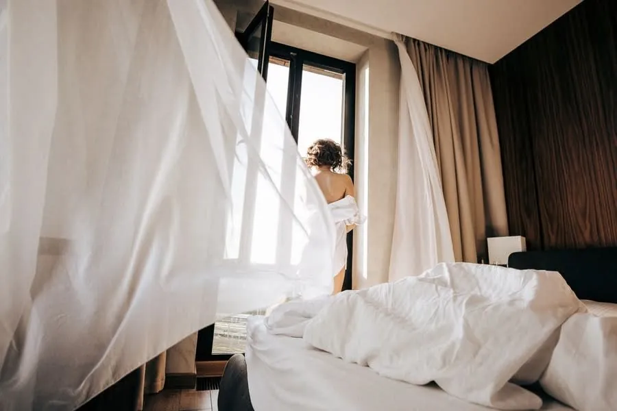 Open casement window with curtains moving in the breeze in an Exeter bedroom