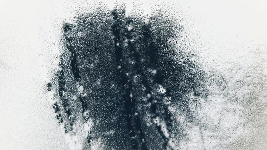 Water droplets and condensation forming on a window pane in a Devon home