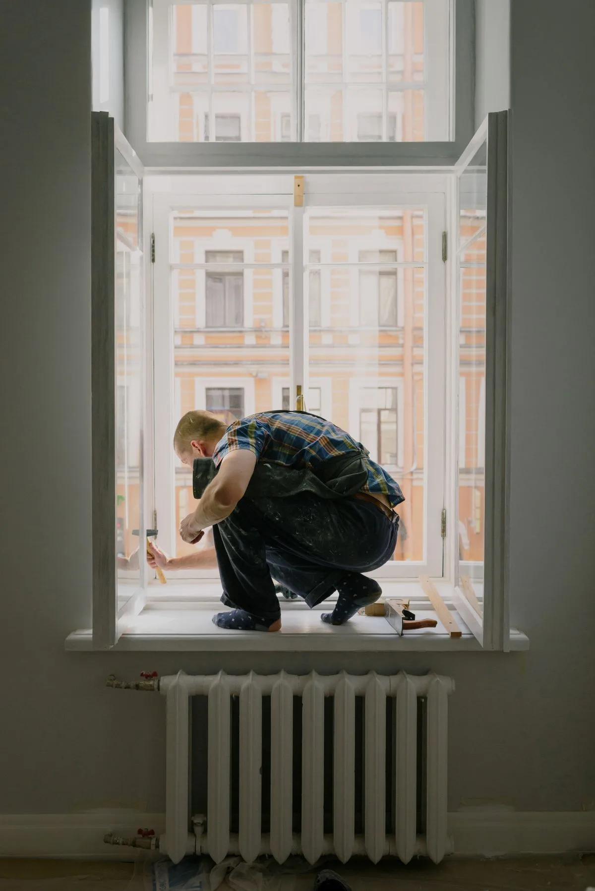 Window fitter working on a windowsill during triple glazing installation in Exeter