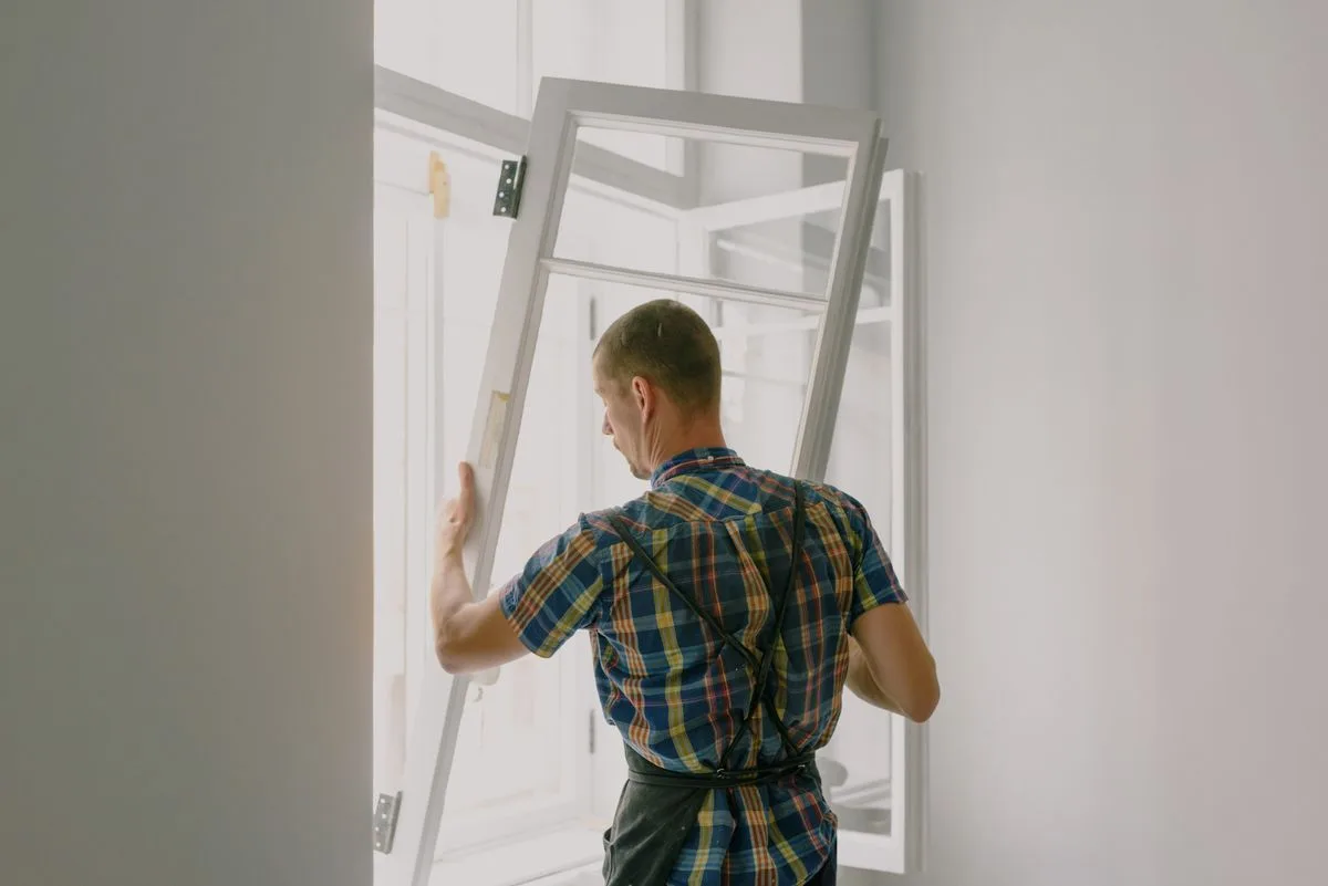 Window installer fitting a casement window in an Exeter property